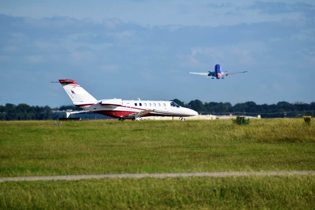 Which are the top executive airports for private jets, and can they also use commercial terminals?